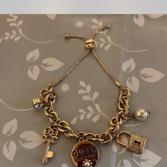 Gold Guess bracelet with pearl and lock charms - Picture 2 of 3